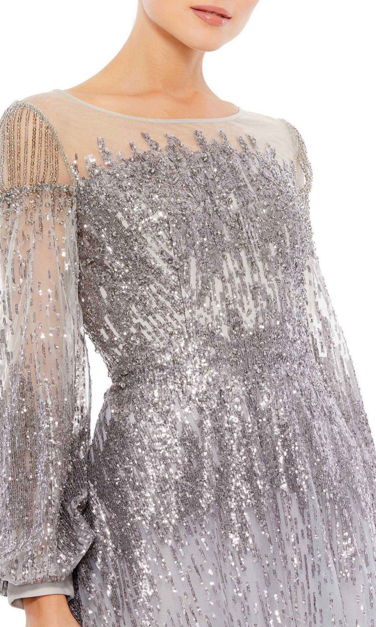 A woman wears the Mac Duggal 20307 Long Sleeve Sequin Formal Gown, a silver sequin-embellished dress with sheer sleeves and beaded shoulders, captured from shoulders to mid-thigh for a glamorous look.